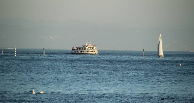 Bateau et voilier sur une grande étendue d'eau.
