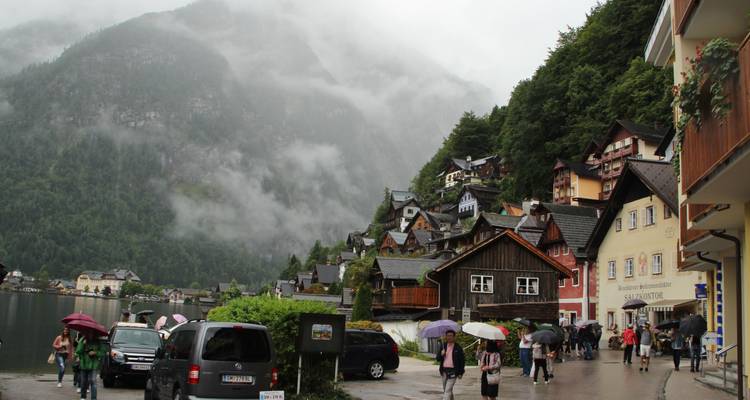 Une scène de village avec des gens qui marchent dans la rue avec des montagnes en arrière-plan.
