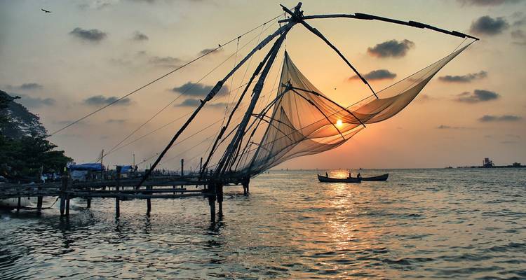Silhouettierte Fischernetze gegen Sonnenuntergang über dem Wasser