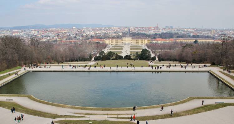 Vista del Palacio de Schönbrunn desde la distancia con un estanque en primer plano.