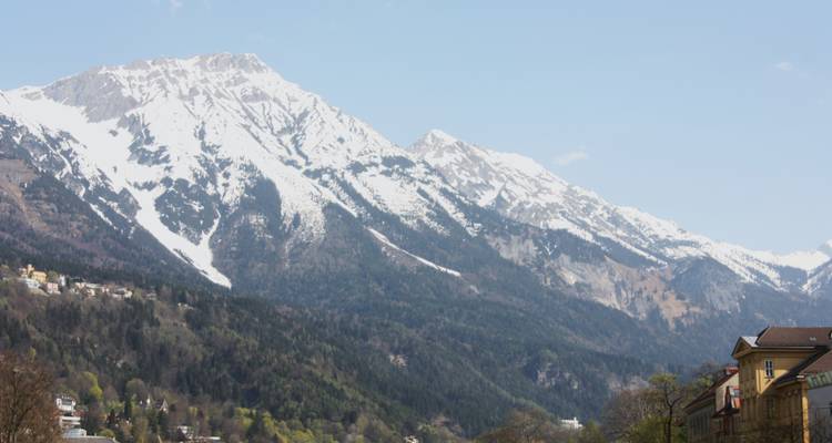 Montañas cubiertas de nieve con un cielo azul claro sobre un pueblo.