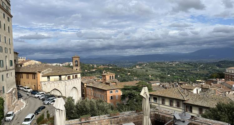 Vista panorámica de un paisaje urbano italiano con edificios antiguos y un cielo nublado.
