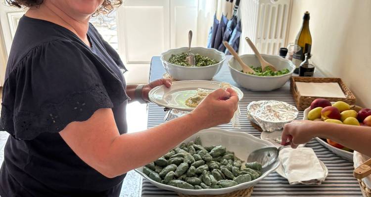Mujer sirviendo platos tradicionales italianos en un buffet.