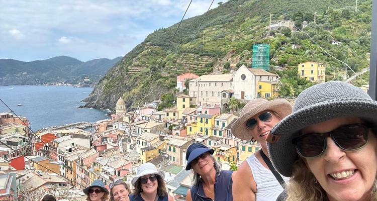 Grupo de personas con vista de un pueblo costero.