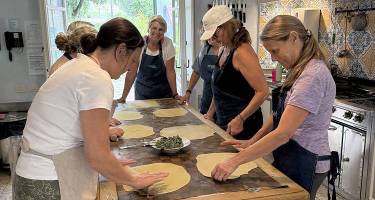 Mujeres participando en una clase de cocina haciendo pasta.