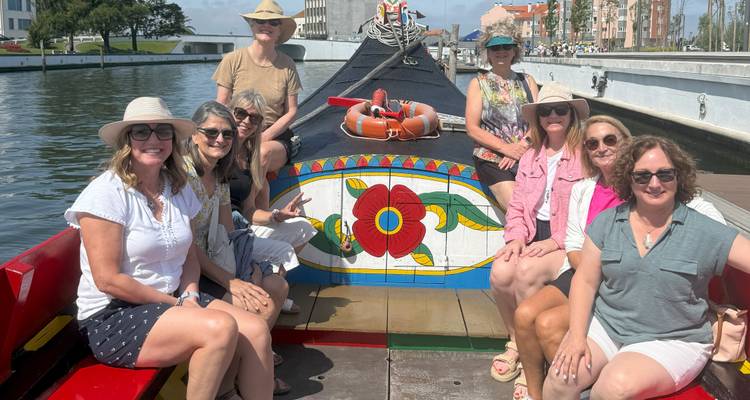 Grupo de mujeres en un barco tradicional con pintura decorativa.