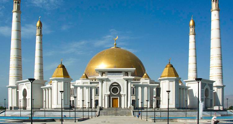 Une grande mosquée avec quatre minarets et un grand dôme doré.