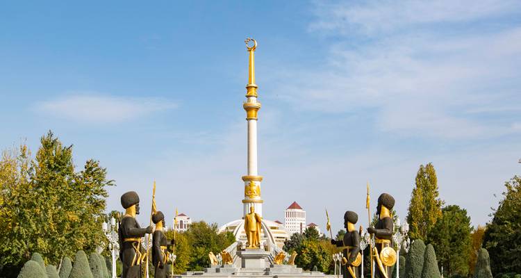 Un monument avec une haute flèche et des statues dorées.
