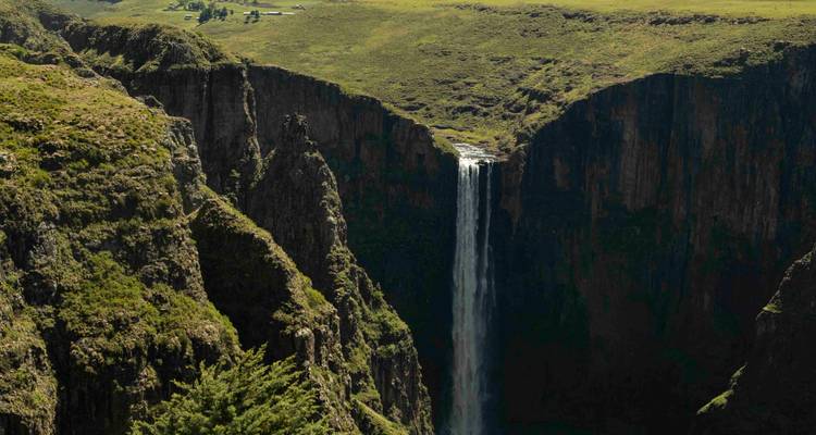 Indrukwekkende waterval die naar beneden stort in een diepe kloof omringd door groen landschap.