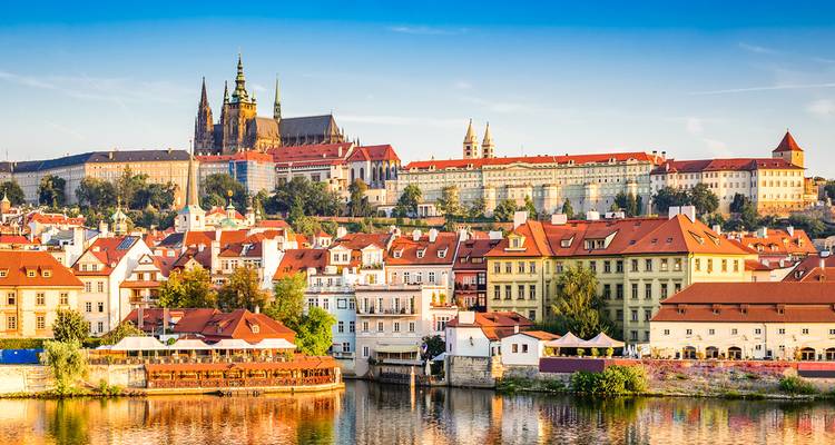 Vista aérea de la histórica Praga con tejados rojos y el castillo prominente.