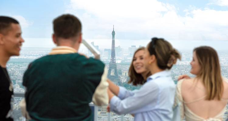 Een groep mensen die een selfie maken met de Eiffeltoren op de achtergrond.