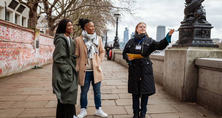 Tourguide die spreekt tegen een stel langs de rivieroever