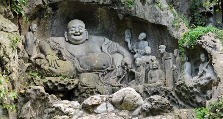 Sculptures de figures bouddhistes taillées dans une paroi rocheuse.