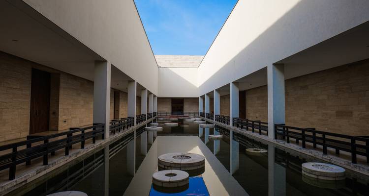 Bâtiment architectural moderne avec un reflet dans l'eau.