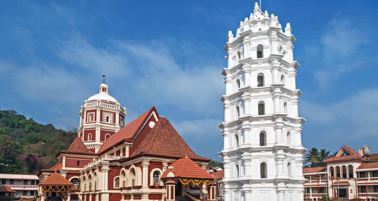 Kerk met een hoge witte toren en gebouwen met rode daken.