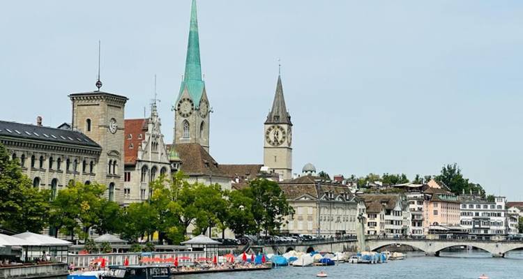 Centre-ville historique avec des clochers proéminents surplombant une rivière.