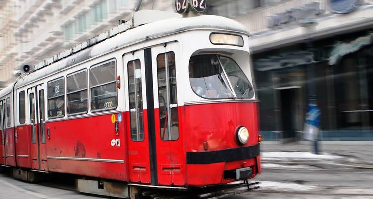 Un tramway rouge se déplaçant le long d'une rue.