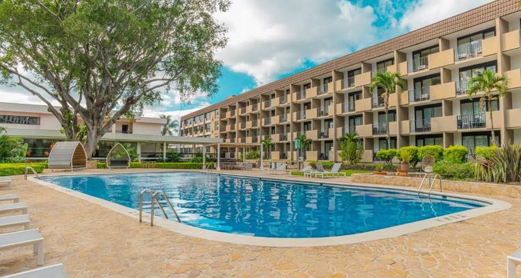 Außenpool-Bereich vor einem großen Hotelgebäude