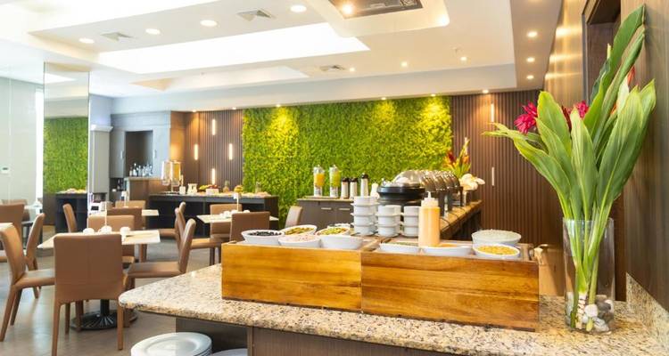 Interior de restaurante con una pared verde y montaje de comedor