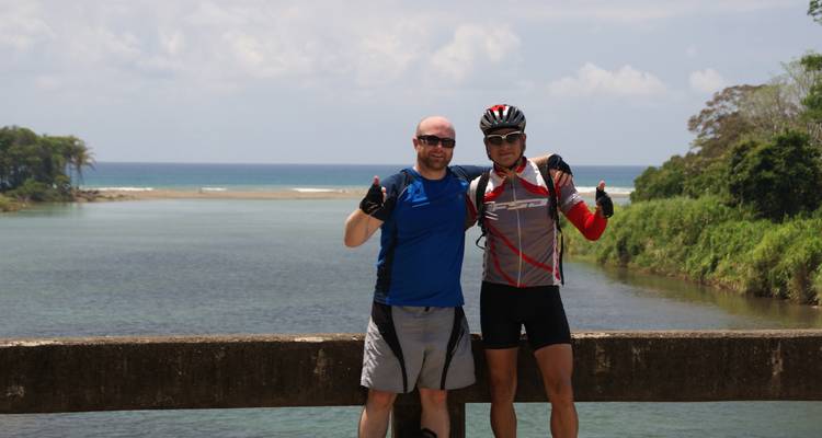 Deux hommes posant pour une photo sur fond de paysage.