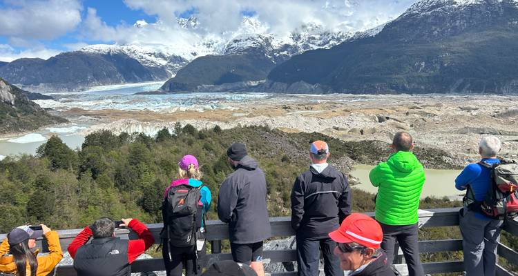 Des visiteurs observant un glacier depuis une plateforme surélevée.