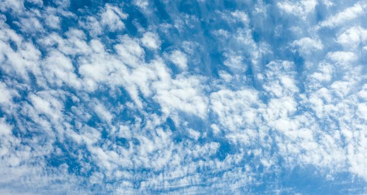 Ciel rempli de nuages épars créant un motif dramatique.