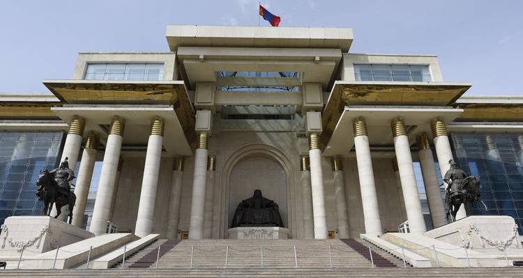 Un gran edificio con una estatua y bandera en el centro.