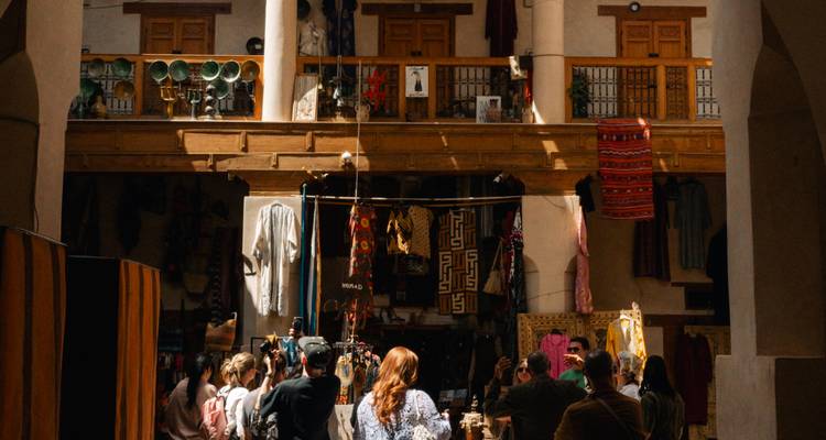 Un bullicioso mercado marroquí lleno de textiles y compradores.