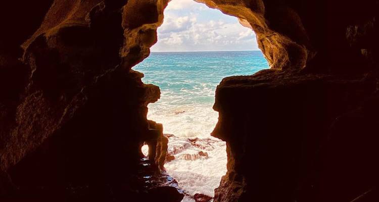Ouverture de grotte avec vue sur l'océan.
