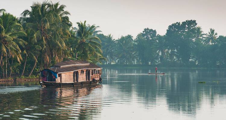 Woonboot op de serene binnenwateren omringd door kokospalmen.