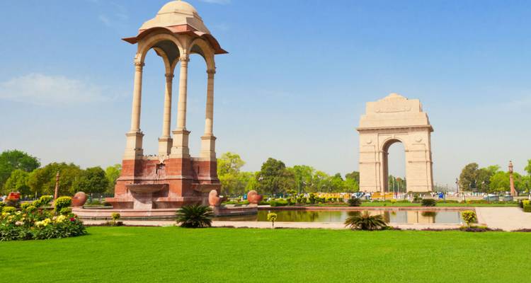 India Gate oorlogsmonument in New Delhi omringd door groen.