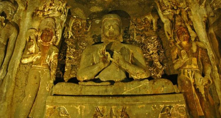 Uitsnijdingen van Boeddha en begeleiders in verblindend licht in de Ajanta-grotten.