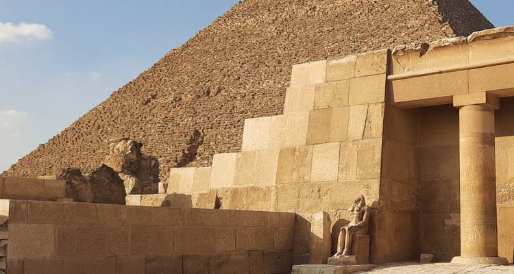 Pirámide y estructuras antiguas con un cielo despejado.