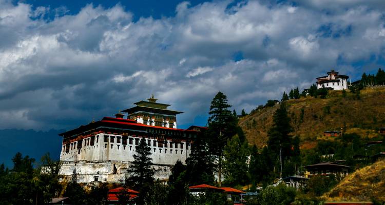 Traditioneel gebouw op een heuvelflank met een bewolkte hemel.