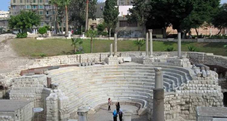 Amphithéâtre de style romain antique avec des gens qui explorent.