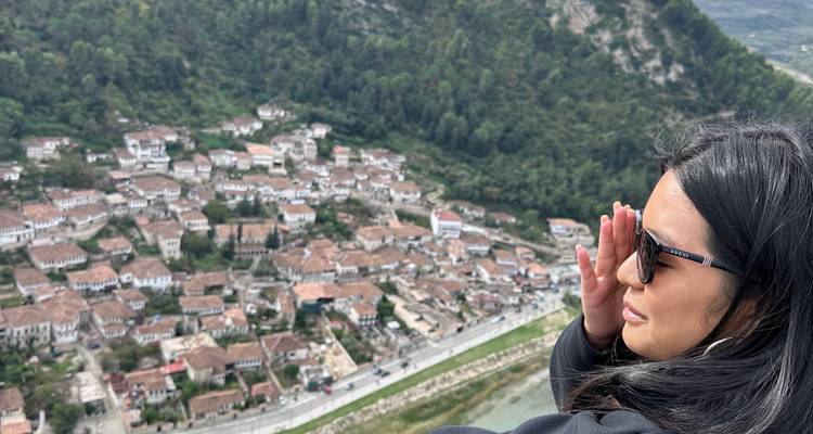 Vista de un pueblo histórico con una mujer disfrutando del paisaje.