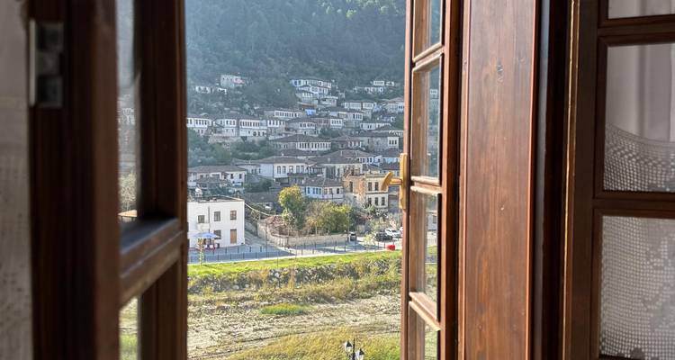 Vista a través de una ventana abierta de un pueblo en la ladera.