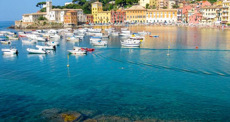 Kustgezicht van Sestri Levante met kleurrijke gebouwen en boten in de baai.