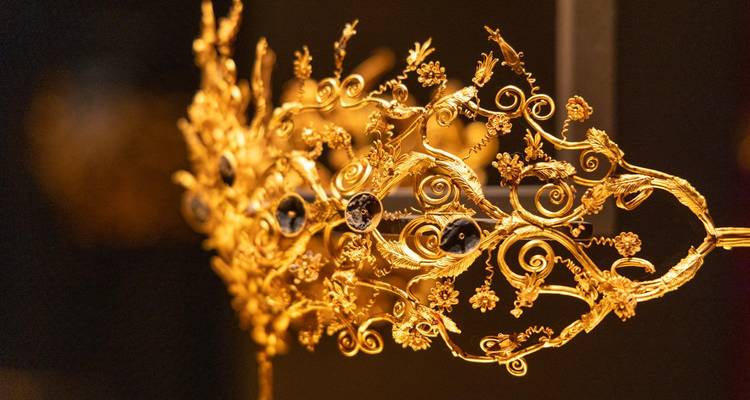 Un primer plano detallado de una diadema dorada y ornamentada.