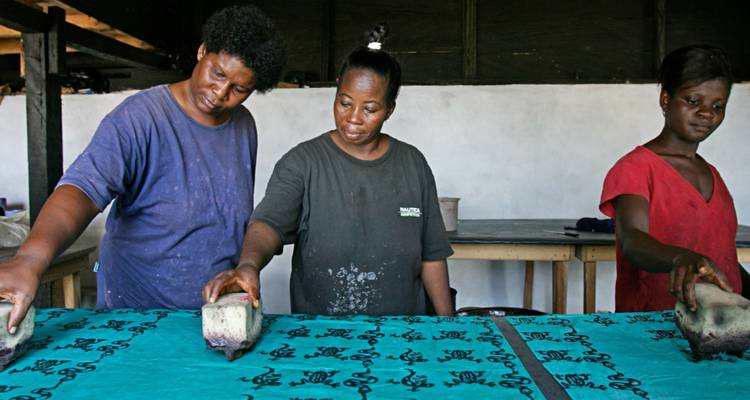 Groep mensen bezig met stofbedrukking met traditionele technieken.