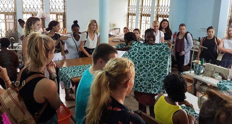 Grote groep mensen in een werkplaats die traditionele ambachten leert.