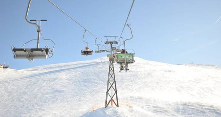 Telesilla transportando personas sobre una pendiente nevada.
