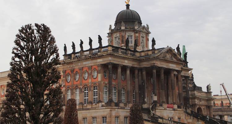 A grand building with statues on the roof.