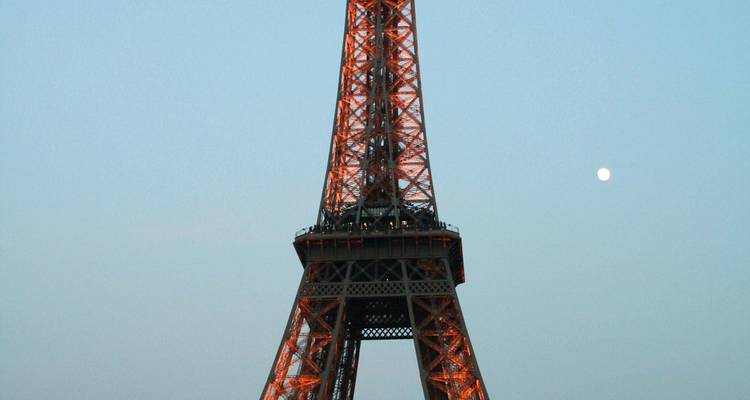 Vista de cerca de una torre icónica iluminada al anochecer.