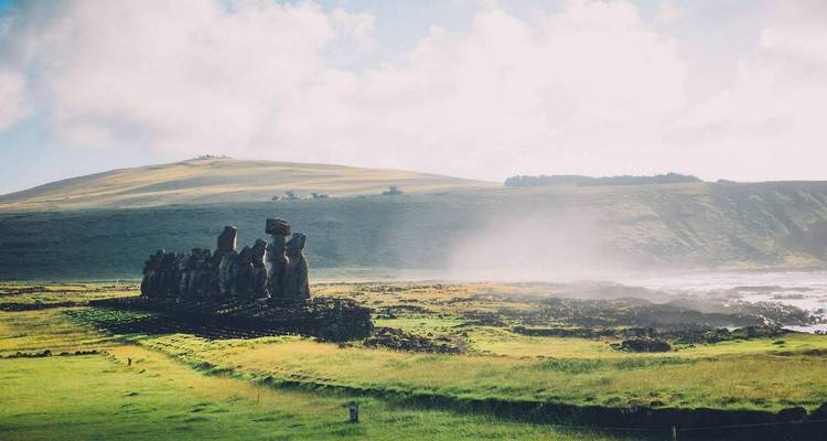 Statues moaï avec de la brume en arrière-plan.