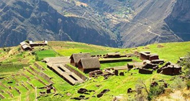 Ruinas en una ladera montañosa con paisajes aterrazados.