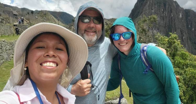 Selfie grupal con las ruinas de Machu Picchu y montañas de fondo.
