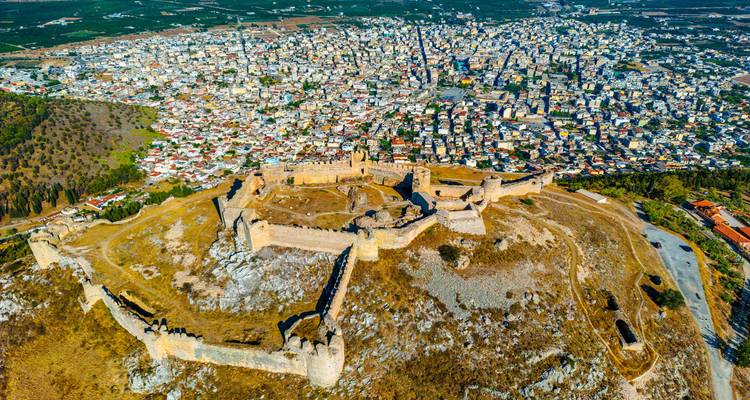 Fortaleza antigua con ciudad al fondo.