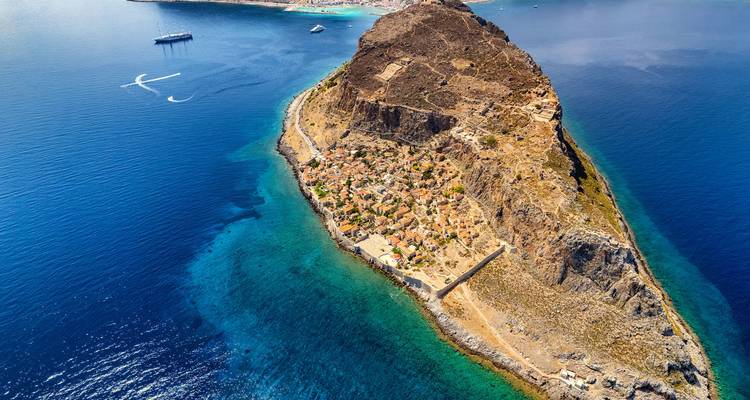 Islote rocoso rodeado por un océano azul cristalino.