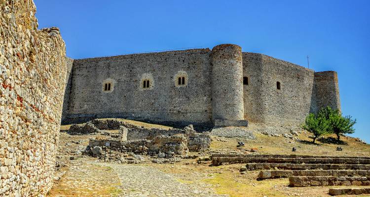 Fortaleza de piedra y ruinas con cielo azul claro.